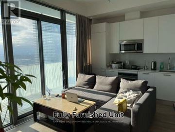 Toronto (Church-Yonge Corridor) condo for rent - A fully furnished living room with a couch, coffee table, and a view of the city.