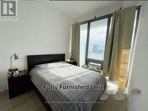 Toronto (Church-Yonge Corridor) condo for rent - A bedroom with a large bed and a window with curtains.