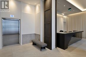 Toronto (Waterfront Communities) condo for rent - A modern office lobby with a bench, a reception desk, and a glass door.