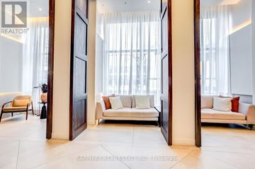 Toronto (Waterfront Communities) condo for rent - A living room with a white couch and a wooden floor.