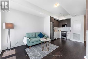 Brampton (Northwest Brampton) condo for rent - A well-lit, modern kitchen and living room with a green couch and a patterned rug.