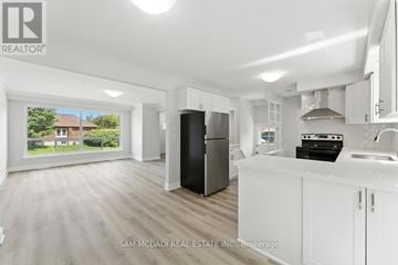 Oshawa (Lakeview) apartment for rent - A modern kitchen with white cabinets and a black refrigerator.