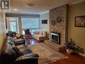 Markham (Thornlea) apartment for rent - A living room with a black leather couch and a fireplace.