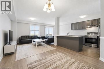 Hamilton townhouse for rent - A well-lit living room with a black sofa and a television.
