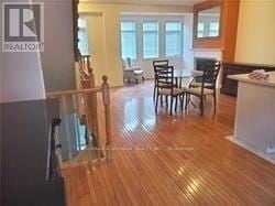 Toronto (Willowdale East) townhouse for rent - A living room with a wooden floor and a dining table with chairs.