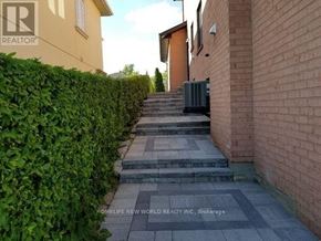 Richmond Hill (North Richvale) apartment for rent - A residential area with a hedge on the left and a brick building on the right.