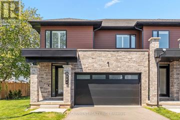 Burlington (Headon) townhouse for rent - A modern house with a stone wall and a black garage door.