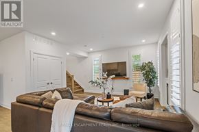 Burlington (Headon) townhouse for rent - A living room with a brown couch and a white blanket on it.