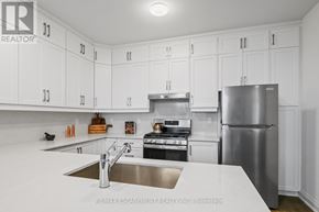Burlington (Headon) townhouse for rent - A kitchen with white cabinets and stainless steel appliances.
