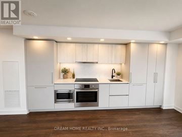 Toronto (North St. James Town) condo for rent - A modern kitchen with white cabinets and stainless steel appliances.