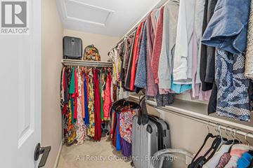 Ottawa apartment for rent - A cluttered closet with clothes and a suitcase.