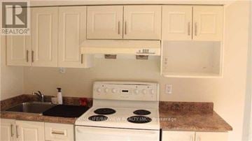 Richmond Hill (Jefferson) townhouse for rent - A white stove and sink in a kitchen with white cabinets.