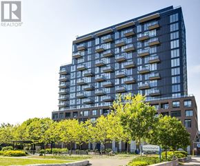 Toronto (South Parkdale) condo for rent - A large building with many windows is surrounded by trees and has a sign that says "Dufferin King Park".