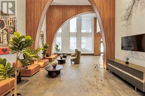 Toronto (South Parkdale) condo for rent - A modern living room with a large arched doorway and a flat screen TV.