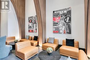 Toronto (South Parkdale) condo for rent - A waiting area with leather chairs and a painting of a Harry Styles concert.