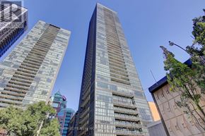 Toronto (Church-Yonge Corridor) condo for rent - A tall building with a glass facade stands in the middle of a cityscape.