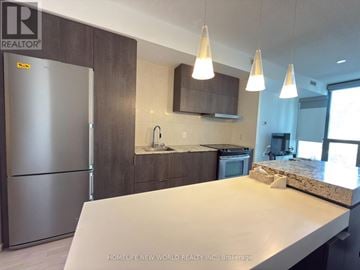 Toronto (Church-Yonge Corridor) condo for rent - A modern kitchen with a stainless steel refrigerator and a marble countertop.