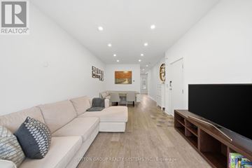 Toronto (Annex) townhouse for rent - A living room with a white couch and a television.