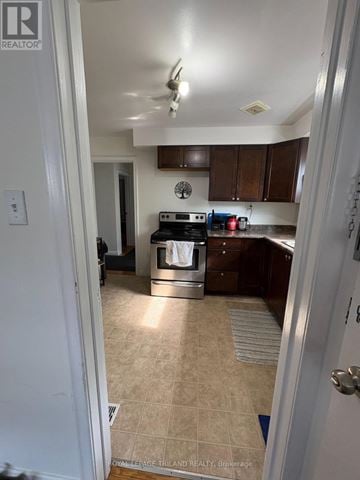 London East (East B) triplex for rent - A kitchen with a tile floor and a stove top oven.