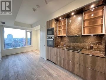 Toronto (Annex) condo for rent - A kitchen with wooden cabinets and a marble backsplash is for sale.