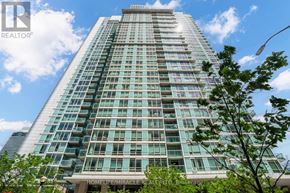 Toronto (Waterfront Communities) condo for rent - A tall building with many windows is surrounded by greenery.
