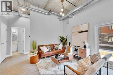 Tecumseh apartment for rent - A living room with a brown couch, a coffee table, and a painting on the wall.