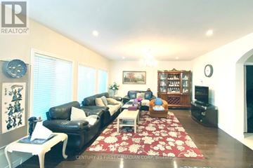 London North (North E) apartment for rent - A living room with a black leather couch and a red floral rug.