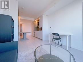 Toronto (Church-Yonge Corridor) condo for rent - A modern living room with a glass table and a black chair.