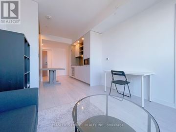 Toronto (Church-Yonge Corridor) condo for rent - A modern living room with a glass table and a black chair.