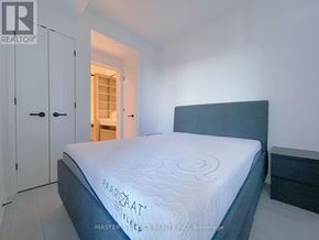 Toronto (Church-Yonge Corridor) condo for rent - A bedroom with a bed, a wardrobe, and a doorway leading to another room.