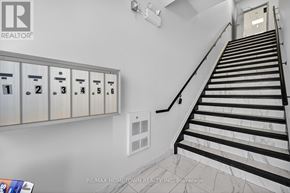 Brockville condo for rent - A staircase with a metal railing and a wall with a row of mailboxes.
