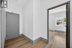 Brockville condo for rent - A room with a wooden floor and white walls, with a door on the left and a window on the right.