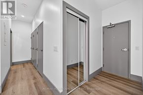 Brockville condo for rent - A hallway with three doors and wooden floors.