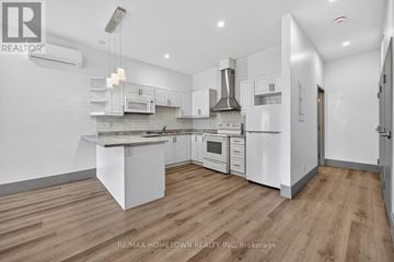 Brockville condo for rent - A modern kitchen with white cabinets and appliances.