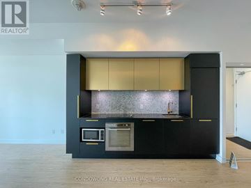 Toronto (Church-Yonge Corridor) condo for rent - A modern kitchen with black cabinets and a stainless steel oven.