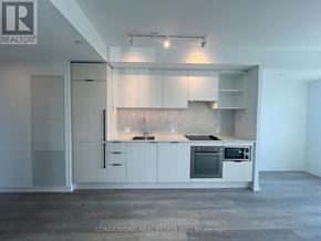 Toronto (Church-Yonge Corridor) condo for rent - A modern kitchen with white cabinets and a marble backsplash.