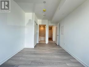 Toronto (Church-Yonge Corridor) condo for rent - A long, empty hallway with a light on the ceiling and doors at the end.