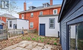 Smiths Falls apartment for rent - A red brick house with a blue door and a grey house with a blue door in front of it.