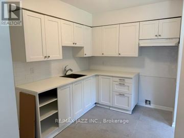 Oshawa (O'neill) multi-family for rent - A kitchen with white cabinets and a sink.