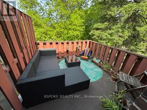 Toronto (Greenwood-Coxwell) apartment for rent - A wooden deck with a hot tub and a black sofa.