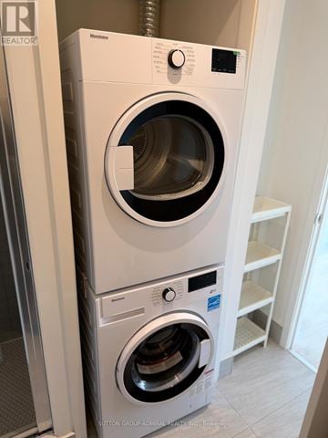 Vaughan (Concord) condo for rent - A white front loading washing machine with a black door is in a room.