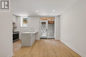 Ottawa apartment for rent - A white room with a kitchen island and a door leading to a balcony.