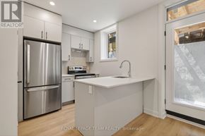 Ottawa apartment for rent - A modern kitchen with a refrigerator, sink, and cabinets.