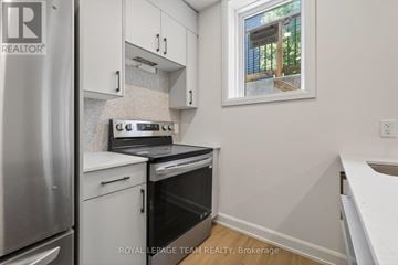 Ottawa apartment for rent - A small kitchen with a stove top oven and a refrigerator.