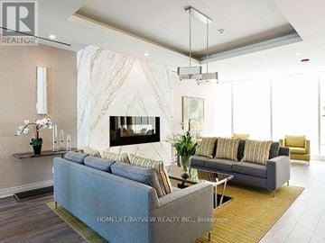 Toronto (Clanton Park) condo for rent - A living room with a grey sofa and a marble wall.