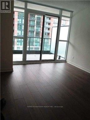 Toronto (Clanton Park) condo for rent - A room with a large window and wooden flooring.