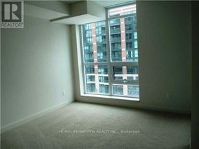 Toronto (Clanton Park) condo for rent - A room with a large window overlooking a building.