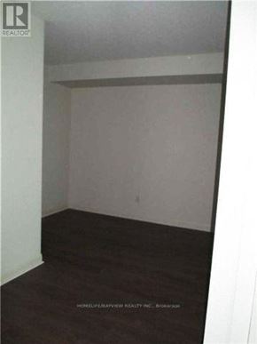 Toronto (Clanton Park) condo for rent - A room with a white wall and a brown floor.