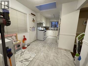 Vancouver townhouse for rent - A kitchen with white cabinets and a marble floor.