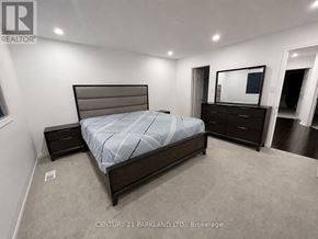 Whitchurch-Stouffville (Stouffville) townhouse for rent - A bedroom with a bed, nightstand, and a dresser with a mirror above it.